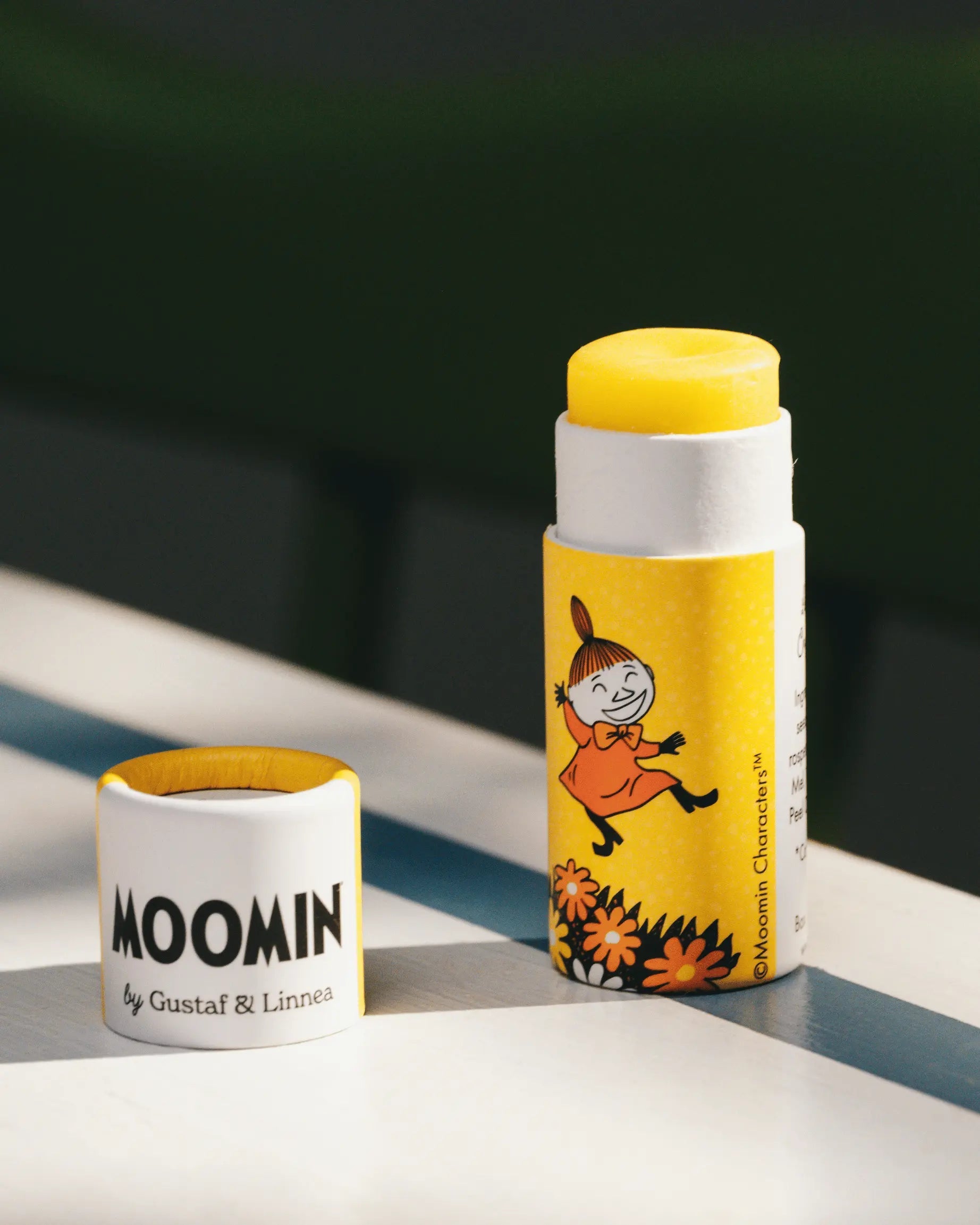Moomin-themed product on a striped surface with a dark background